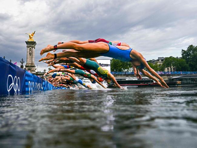 (FILES) Athletes compete in the swimming race in the Seine during the women's individual triathlon at the Paris 2024 Olympic Games in central Paris on July 31, 2024. Paris Olympics organisers have cancelled training for triathletes in the River Seine again because of poor water quality, leading to more uncertainty over whether the mixed relay will go ahead as planned on August 5, 2024. (Photo by MARTIN BUREAU / POOL / AFP)