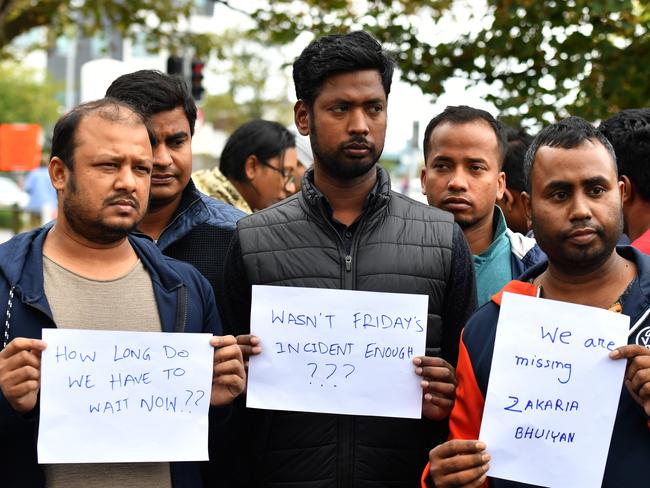 Friends of a missing man Zakaria Bhuiyan hold up signs of him outside a refuge centre in Christchurch. Picture: AAP