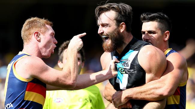 Adelaide Crows’ Taylor Walker holds back Port’s Charlie Dixon from a confrontation with Tom Lynch.