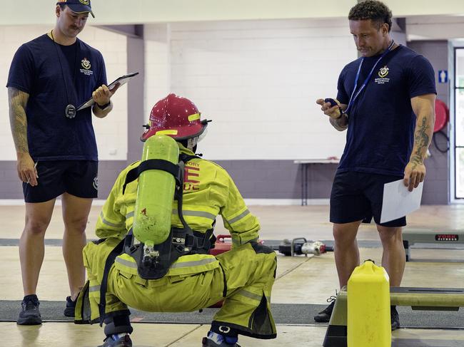 Firefighter Lachlan Parsons and Firefighter Matthew Oliver time a participant holding 20kg vehicle cutters during the NTFRS Come and Try Day. Picture: NTFRS / Supplied.