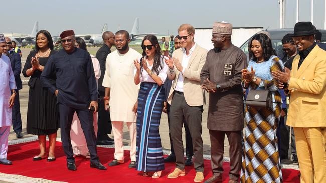 Prince Harry and Meghan after deboarding their Air Peace aircraft, with Dr Allen Onyema, pictured dressed in navy and wearing a red kufi hat. Picture: X/@flyairpeace