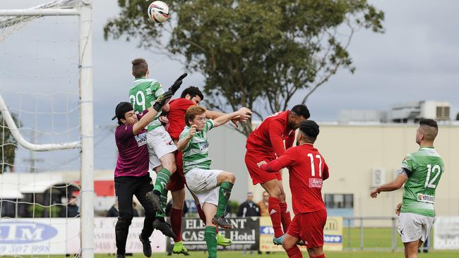 Whittlesea United forwards climb in an effort to win a header in the penalty area. Picture: Alan Barber