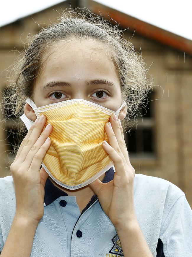 Aliya Raab from Leichhardt Campus of Sydney Secondary College with a dust mask in protest to the site behind her. Picture: John Appleyard