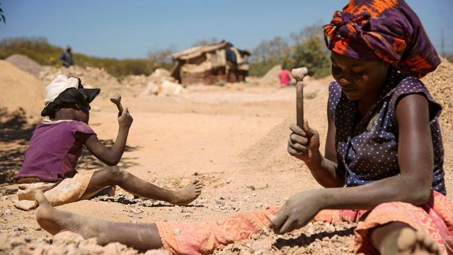 A child and a woman break rocks extracted from a cobalt mine at a copper quarry and cobalt pit in the DRC. Picture: Junior Kannah / AFP