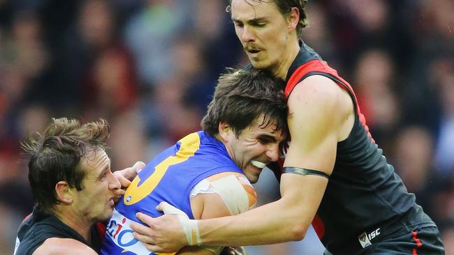 Jobe Watson and Joe Daniher tackle Eagle Andrew Gaff.