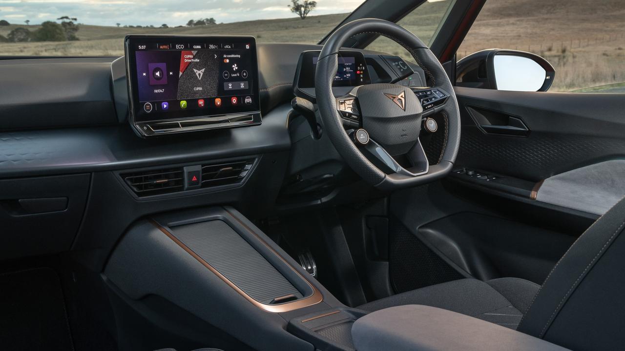 The Cupra Born cabin features a 12-inch infotainment screen, suede-type finishes on the seats and console, wired Apple CarPlay and Android Auto, wireless phone charging and keyless entry with push-button start.