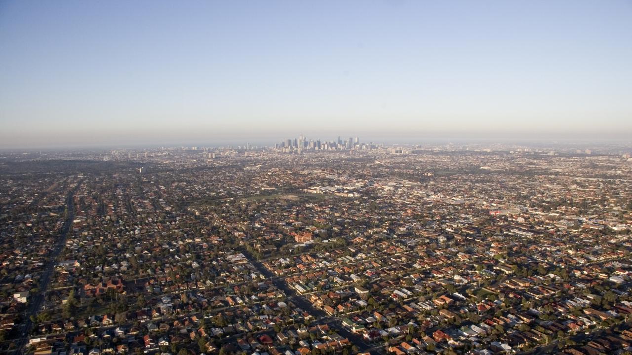 An aerial view of Melbourne and surrounding suburbs, where thousands of migrants are competing with locals for housing and resources, growing the economy but sending individuals backwards.