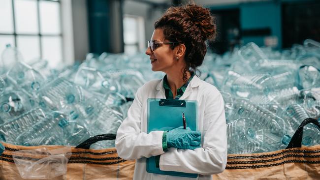 Young happy female worker in bottling factory recycling department. Inspection quality control.