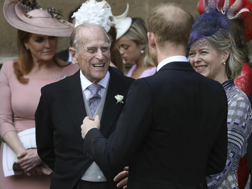 Prince Philip talks to Prince Harry, right, as they leave after the wedding of Lady Gabriella Windsor and Thomas Kingston. Picture: AP