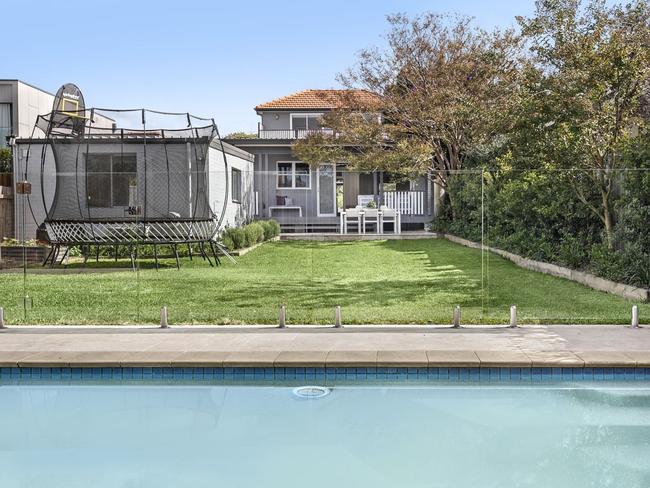 The backyard is level and has a swimming pool.