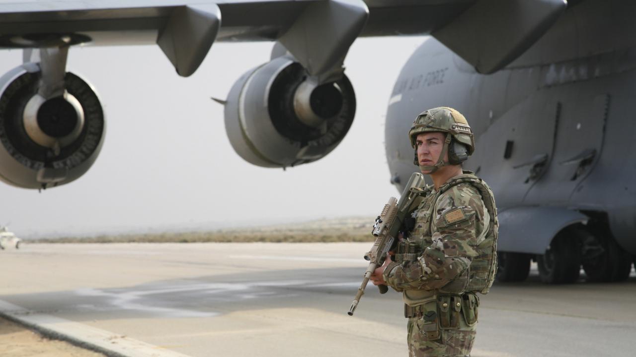 Leading Aircraftsman Toby Page stands watch as a Royal Australian Air Force (RAAF) C-17A Globemaster III strategic airlifter is unloaded at El Gorah airfield in northeast Sinai, Egypt.