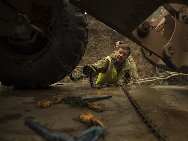 Plant operator Cpl. Duncan Keith unloading a 434 backhoe to assist staff from Forestry Management Victoria to clear fire damaged trees from the great Alpine road between Bairnsdale and Omeo during Operation Bushfire Assist 19-20 near Bairnsdale, Victoria, Australia. Picture: Department of Defence via AP