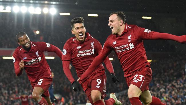 Liverpool's Swiss midfielder Xherdan Shaqiri (C) celebrates with Liverpool's Dutch midfielder Georginio Wijnaldum (L) and Liverpool's Brazilian midfielder Roberto Firmino (2nd L) after scoring their third goal during the English Premier League football match between Liverpool and Manchester United at Anfield in Liverpool, north west England on December 16, 2018. (Photo by Paul ELLIS / AFP) / RESTRICTED TO EDITORIAL USE. No use with unauthorized audio, video, data, fixture lists, club/league logos or 'live' services. Online in-match use limited to 120 images. An additional 40 images may be used in extra time. No video emulation. Social media in-match use limited to 120 images. An additional 40 images may be used in extra time. No use in betting publications, games or single club/league/player publications. /