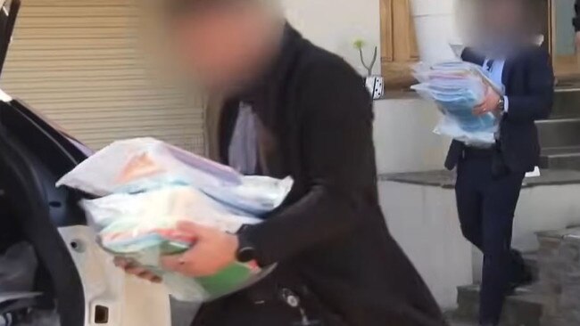 AFP and NDIS officers seize documents as part of the investigation. Picture: 7NEWS