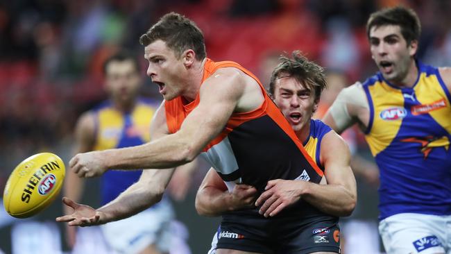 Giants Heath Shaw handballs ahead of West Coast's Luke Partington.