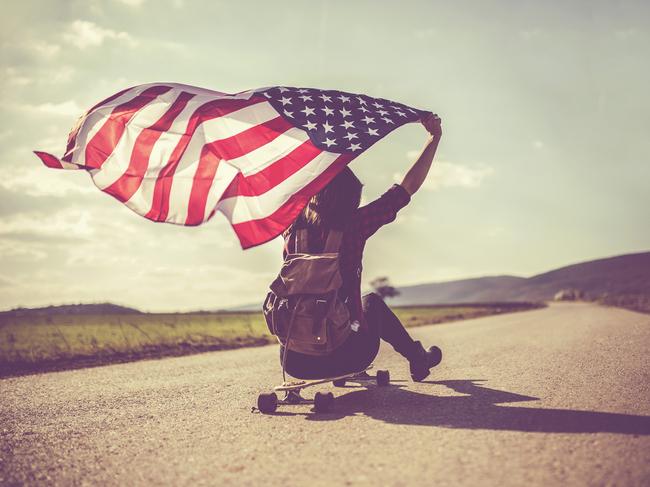 FemaleTeenage American skater flying an American flag