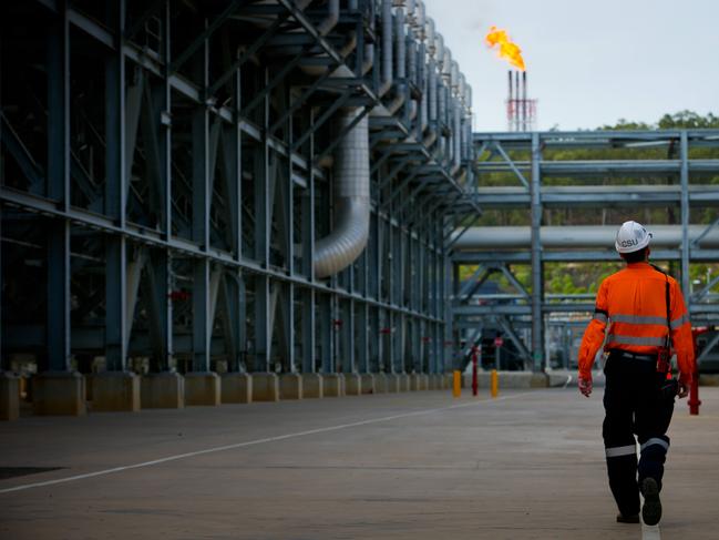 A worker walks through the Queensland Curtis Liquefied Natural Gas (QCLNG) project site, operated by QGC Pty, a unit of Royal Dutch Shell Plc, in Gladstone, Australia, on Wednesday, June 15, 2016. Gas from more than 2,500 wells travels hundreds of miles by pipeline to the project, where it's chilled and pumped into 10-story-high tanks before being loaded onto massive ships. Photographer: Patrick Hamilton/Bloomberg via Getty Images