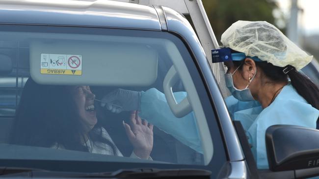 A medical worker tests a woman in her car at the Crossroads Hotel in Sydney on Monday. Picture: AFP