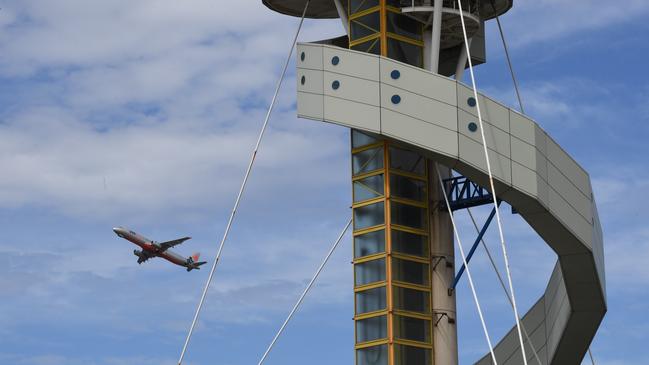 The control tower at Sydney Airport is seen as a plane takes off in Sydney, Friday, March 29, 2019. Flights are slowly resuming after Sydney Airport's air traffic control tower was evacuated after smoke was detected inside. (AAP Image/Peter Rae) NO ARCHIVING