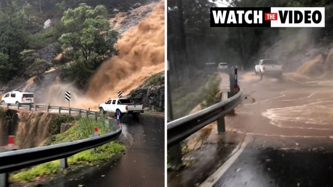 Waterfall cascades over mountain road