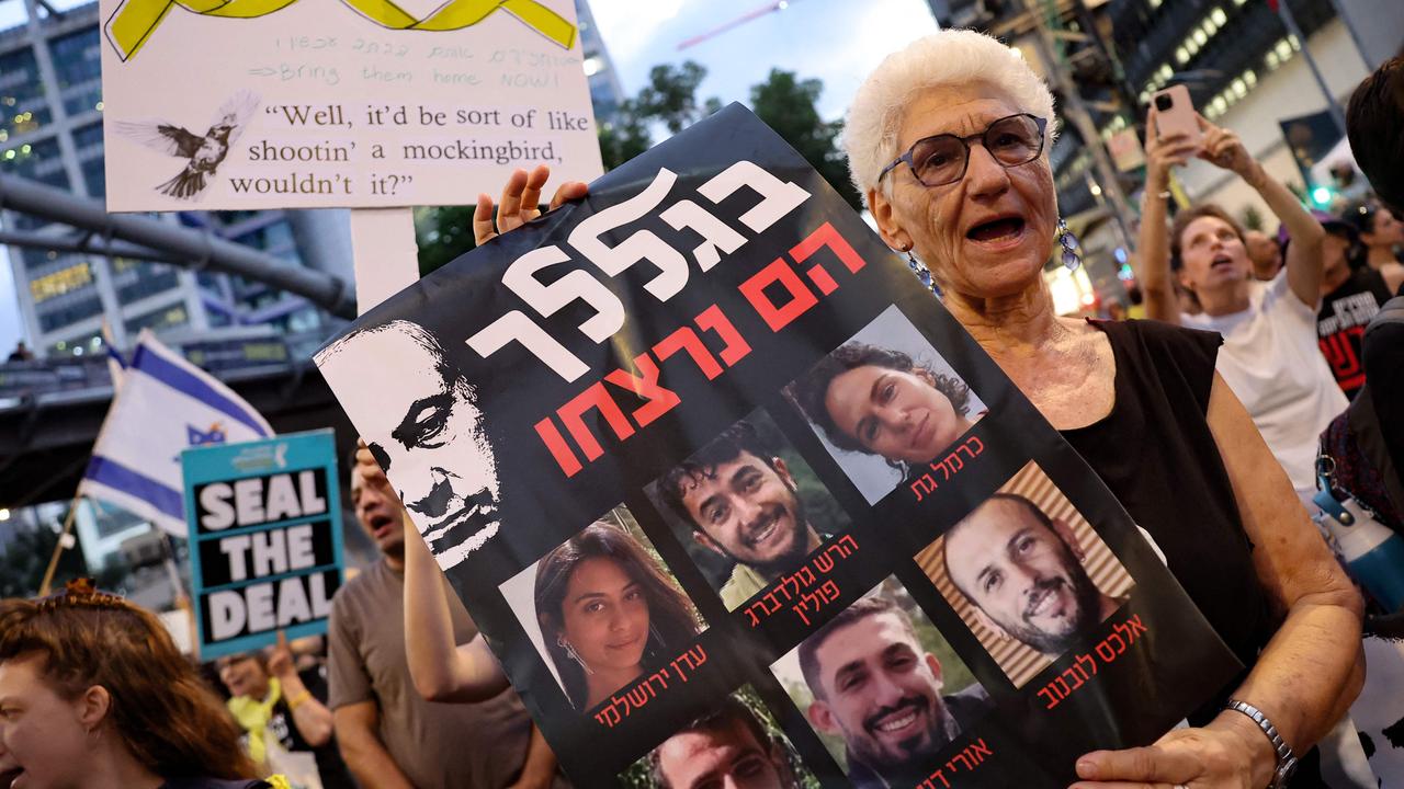 A demonstrator with a sign bearing pictures of the recently killed six hostages, during an anti-government protest calling for action to secure the release of Israeli hostages. Picture: AFP