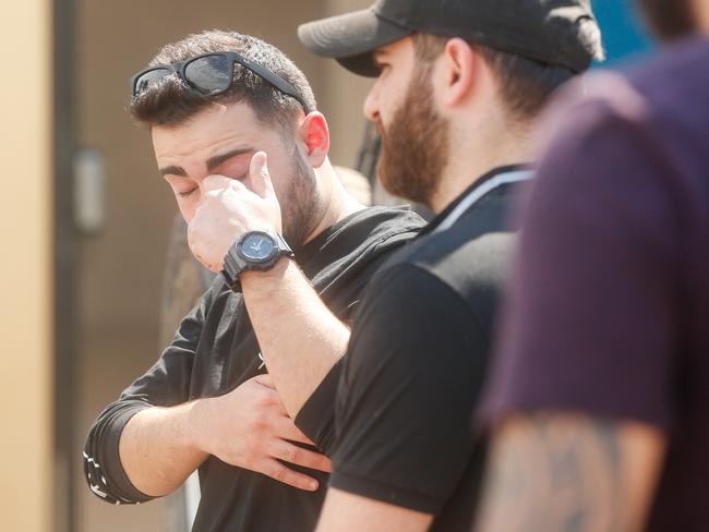 Family members and co-workers look on as the body of Hassan Baydoun is removed from a unit at the Palms Motel. Picture: Glenn Campbell