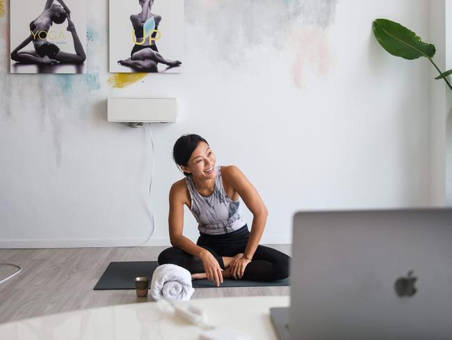 YogaUP founder Chaukei Ngai smiles after concluding a live streamed yoga class via Zoom. Industry experts say online fitness platforms are here to stay. Picture: Anthony Walace/AFP