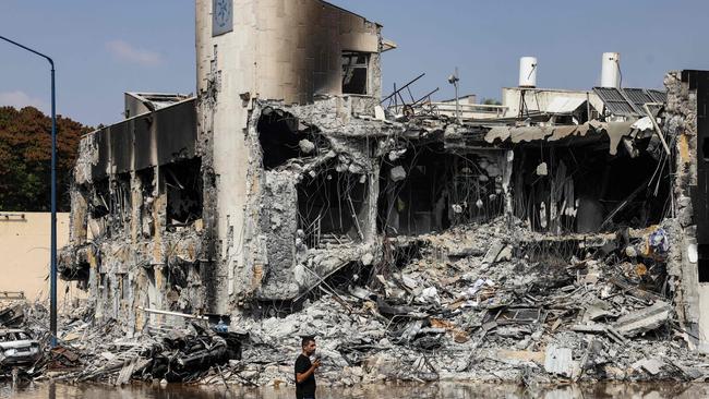 A man walks past an Israeli police station in Sderot after it was damaged during battles to dislodge Hamas militants who were stationed inside. (Photo by RONALDO SCHEMIDT / AFP)