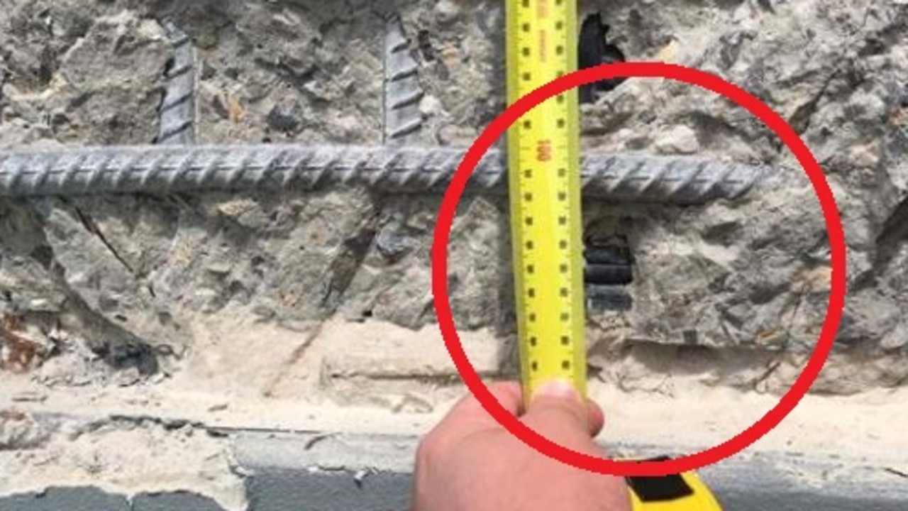 A photo from the report shows the exposed grout between the panel, the hob beam and a plastic sheath (right of tape measure).