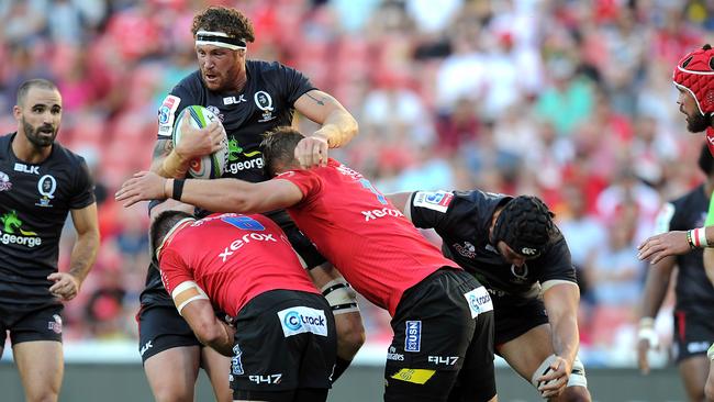 Jack Kriel (R) and Malcolm Marx (L) of the Lions tackle Scott Higginbotham (C) of the Reds during the Super XV rugby union match between The Lions and the Queensland Reds at Ellis Park Stadium on March 18, 2017 in Johannesburg, South Africa. / AFP PHOTO / STRINGER