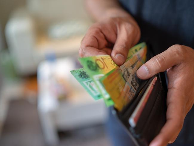 a male taking money out of a wallet, Australian cash generic spending