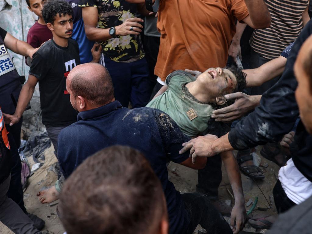 People carry a young boy pulled from under the rubble of a house destroyed in an Israeli strike on Rafah in the southern Gaza Strip. Picture: AFP