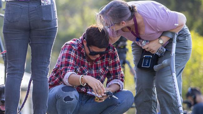 A Canungra fire evacuee is comforted during a community meeting outside Moriarty Park Hall in Canungra on Sunday. Picture: AAP Image/Glenn Hunt.