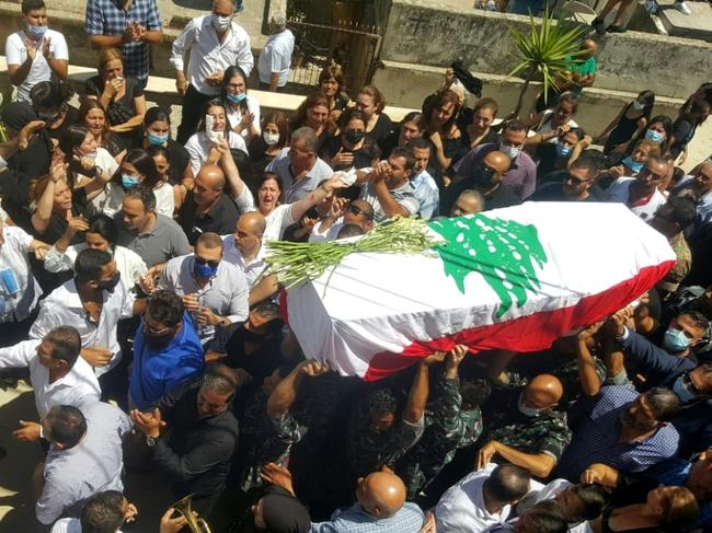 Lebanese mourners walk in the funeral procession of firefighter Michel Khuzami, killed in this week's Beirut explosion. Picture: AFP