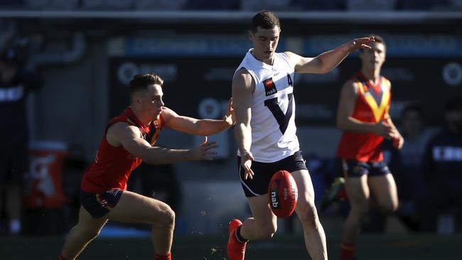 Vic Country’s Sam Flanders gets a kick away in front of Jed McEntee of South Australia. Picture: Dylan Burns/AFL Photos via Getty Images