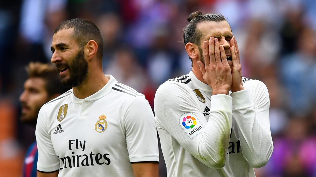 Gareth Bale (R) reacts next to Karim Benzema. (Photo by GABRIEL BOUYS / AFP)