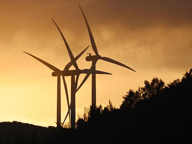 Wind turbines are seen at sunset on Pingtan Island, in China's southeast Fujian province on January 16, 2024. (Photo by GREG BAKER / AFP)