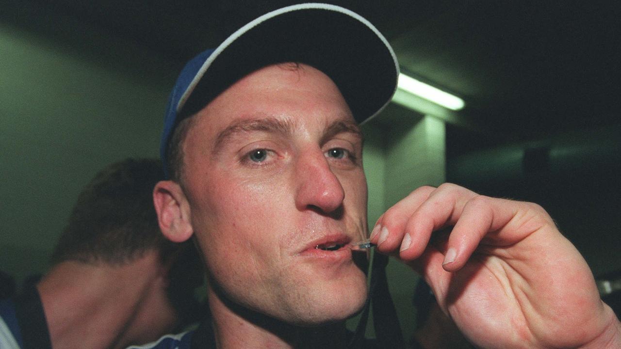 John Longmire kisses his premiership medallion. Medal. it was his 200th game. 1999 Grand Final. North Melbourne (Kangaroos) v Carlton. MCG.