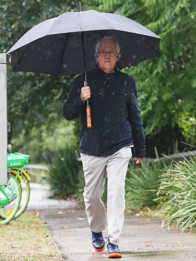 Former PM Malcolm Turnbull walks in the rain near his home at Point Piper, Sydney. Picture: John Feder