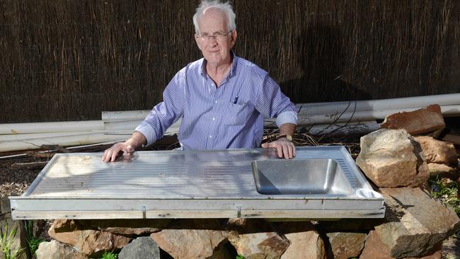Chris Short with an makeshift, outdoor sink one Adelaide family has had to use for more than a year due to an issue with their kitchen renovation. Picture: AAP Image/ Brenton Edwards