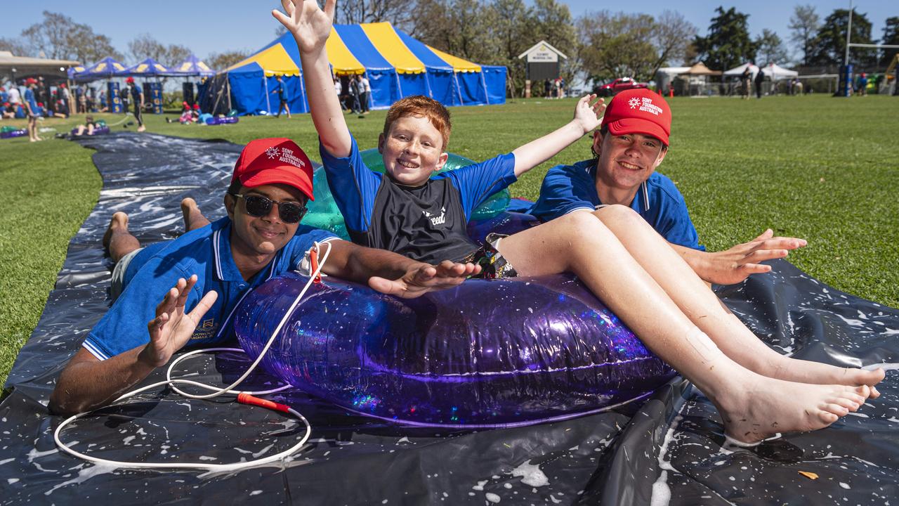 Toowoomba Grammar School students Anuk Fernando (left) and Ned Sullivan with Hunter on the slip and slide as TGS hosts the Sony Foundation Children’s Holiday Camp, Monday, September 16, 2024. Picture: Kevin Farmer