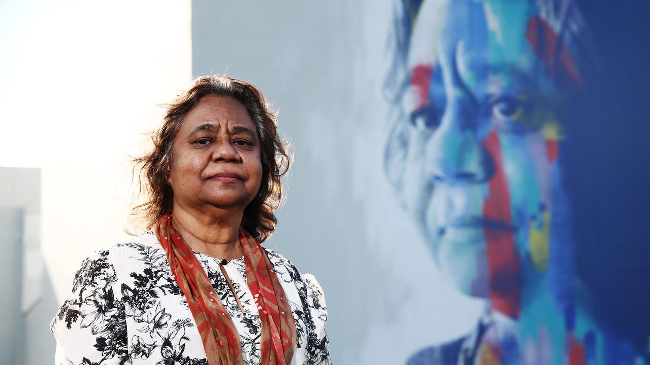 Henrietta Marrie standing beside a striking mural of her on Lake Street, Cairns city. PICTURE: BRENDAN RADKE