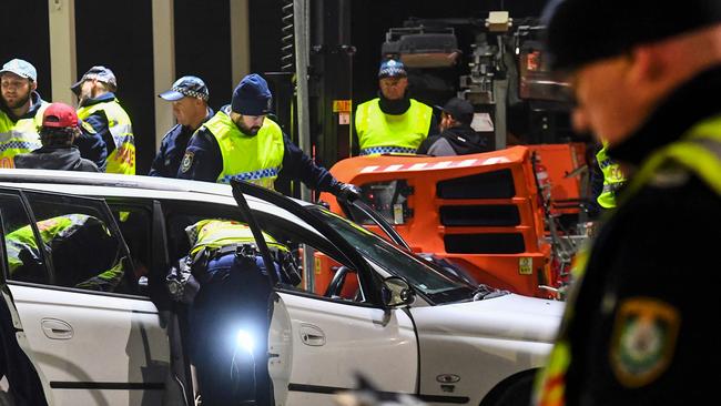 Police in the southern New South Wales (NSW) border city of Albury check cars crossing the state border from Victoria on July 8, 2020 after authorities closed the border due to an outbreak of COVID-19 coronavirus in Victoria. - With the city of Melbourne going into lockdown for the next six weeks, the entire state of Victoria will effectively be sealed off from the rest of the country with the state border to NSW closing on 08 July. (Photo by William WEST / AFP)