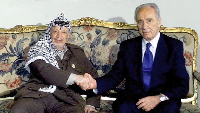 Palestinian leader Yasser Arafat shakes hands with then Israeli Foreign Minister Shimon Peres. Picture: AFP.