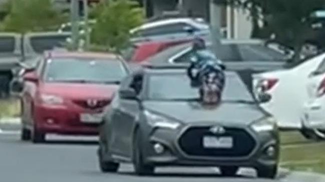 The car is moving as the boy clings on. Picture: Channel 9