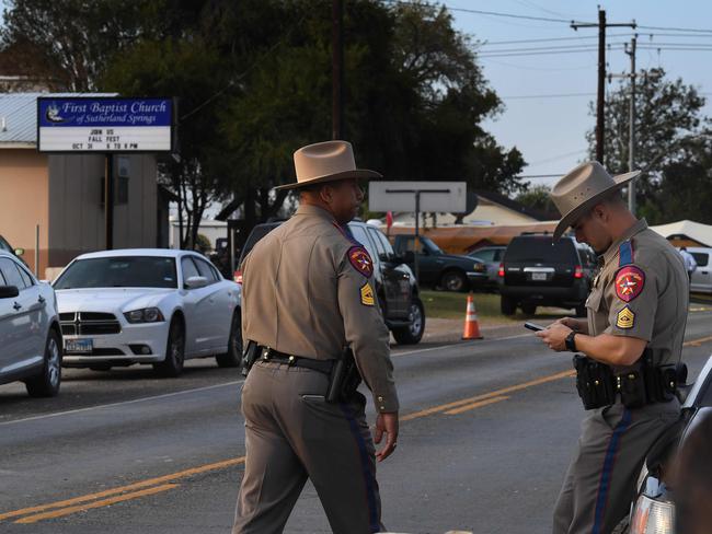 State troopers patrol at the entrance to the First Baptist Church (back) after a mass shooting that killed 26 people in Sutherland Springs, Texas on November 6, 2017 Picture: AP.