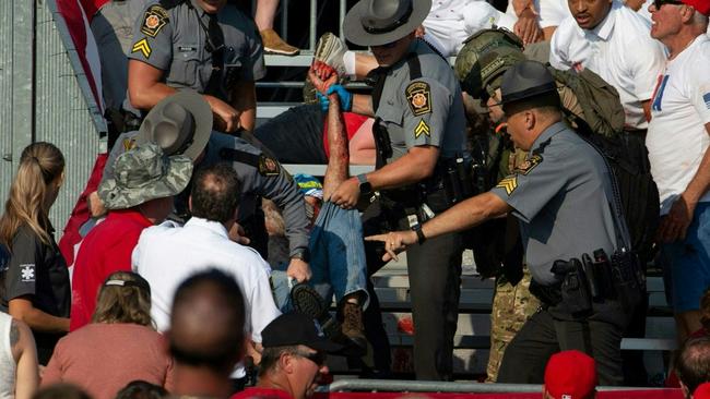 A person is removed by state police from the stands. Picture: AFP