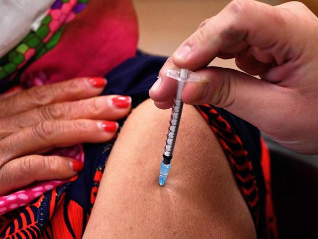 A woman gets her first dose of AstraZeneca vaccine at a walk-in clinic inside a Buddhist temple in the Smithfield suburb of Sydney. Picture: AFP