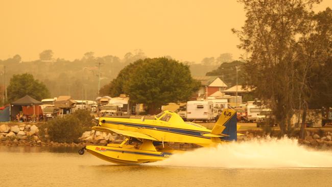 A water bombing aircraft refills on the Moruya River. Picture: John Grainger