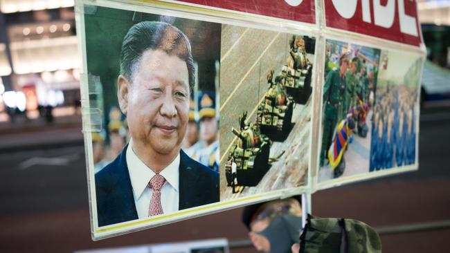 A protester holds up a placard with a picture of Xi Jinping during a rally for victims of China's zero-Covid policy outside Shinjuku Stationin Tokyo, Japan. Picture: Getty Images)